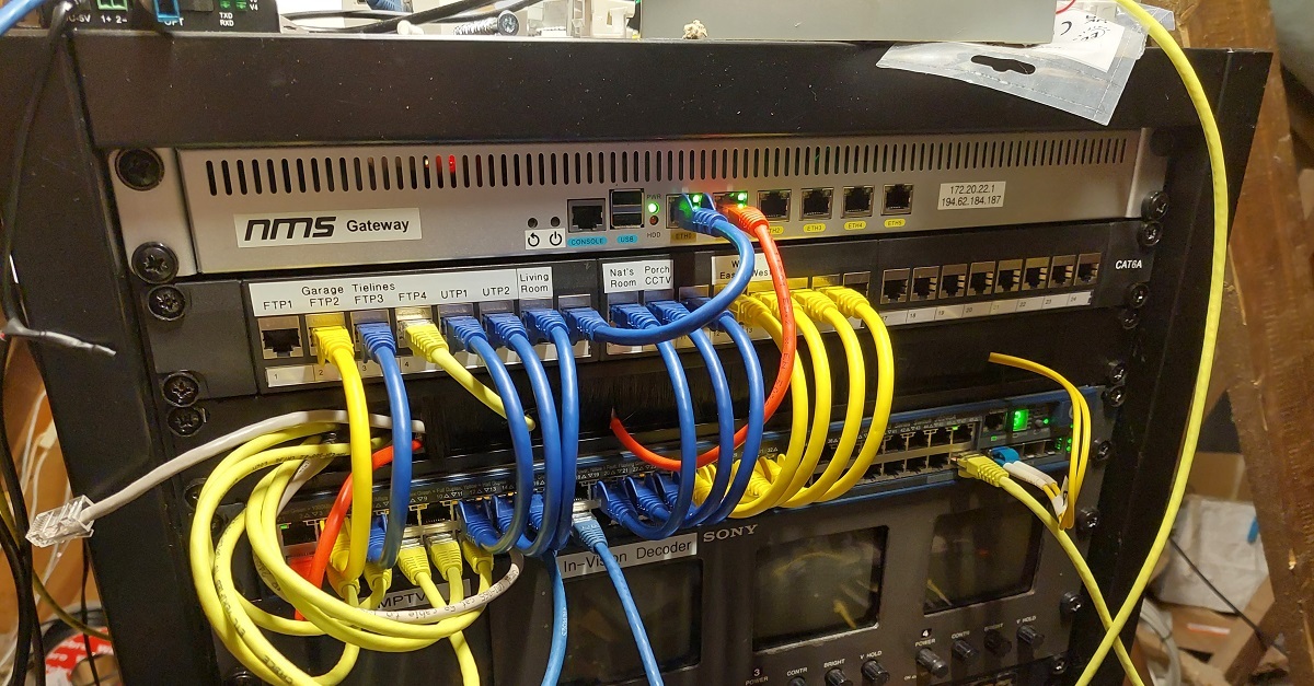 19 inch equipment rack containing an aluminium router. It has six ethernet ports, and is marked with a sticker that says 'NMS Gateway' and some IP addresses.