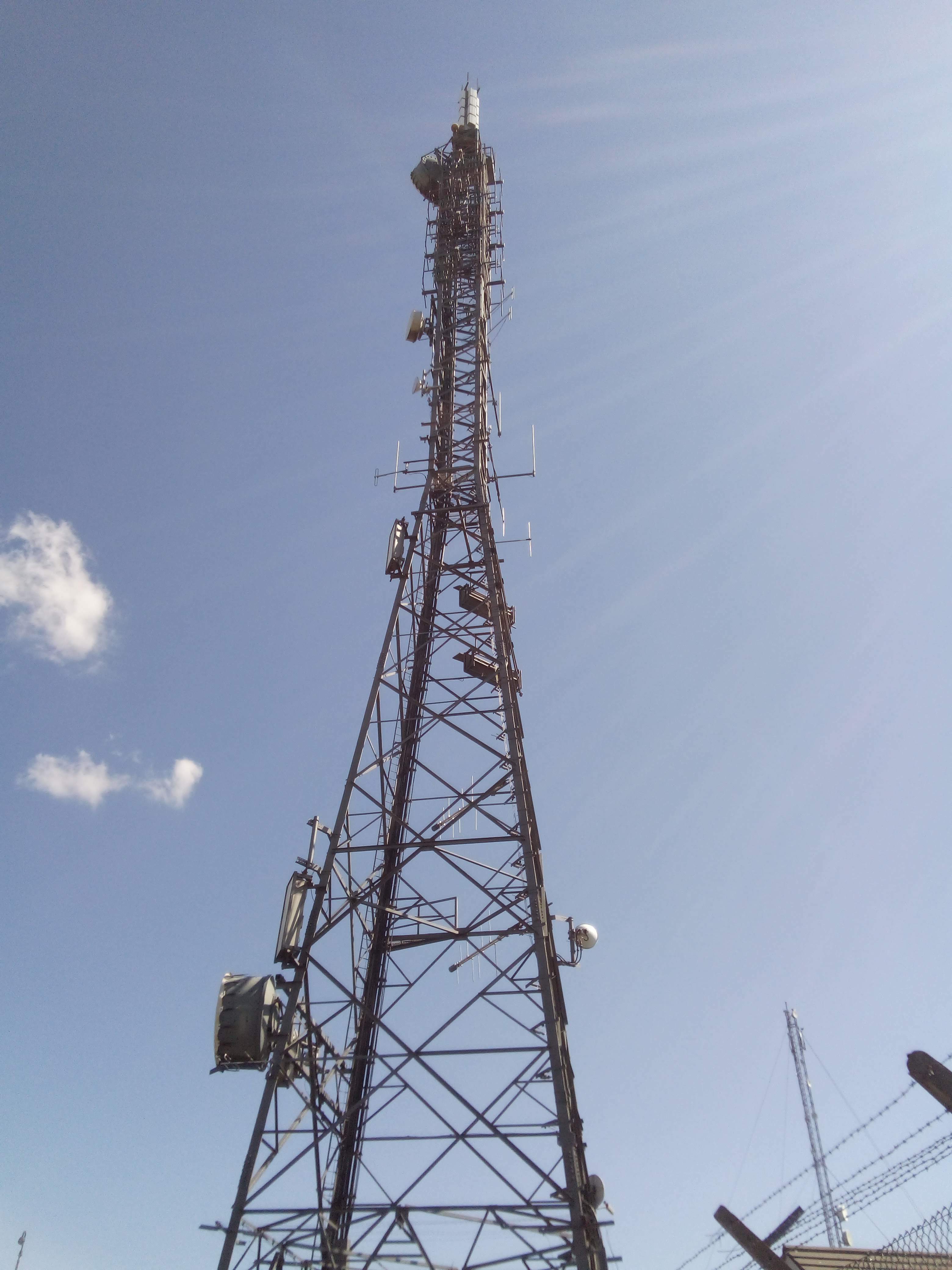 Mast A. This features a number of trough antennas as well as folded and normal dipole antennas. An access ladder scales the side. At the top there's another DTT panel antenna and an FM array.