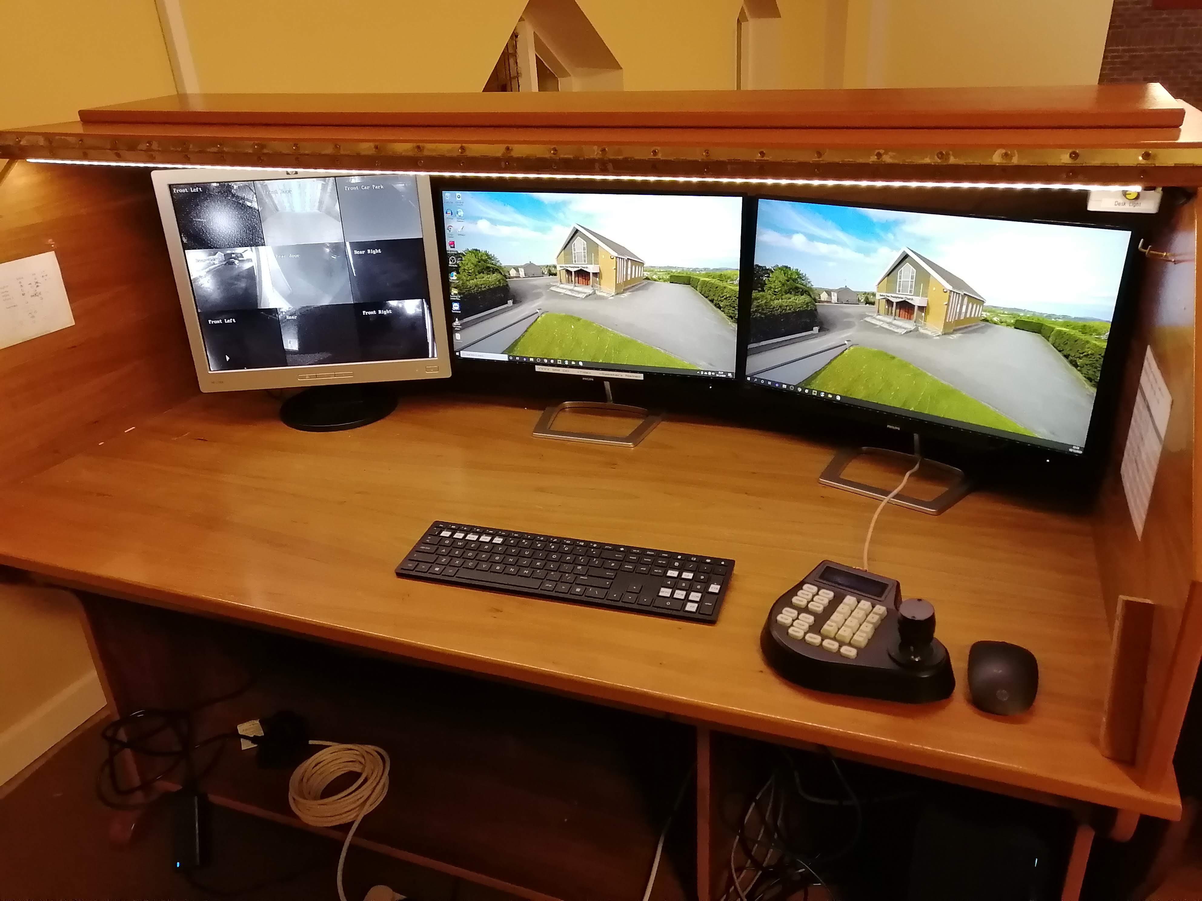 Tidy desk with three monitors, keyboard, joystick etc
