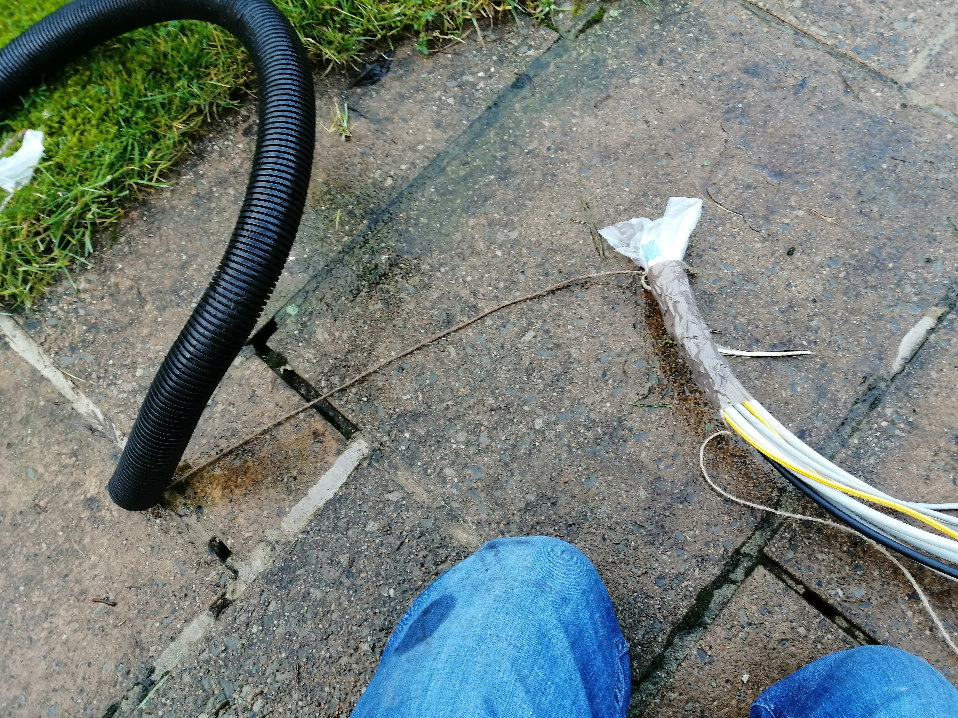 cables taped up and tied to a rope leading inside a conduit tube